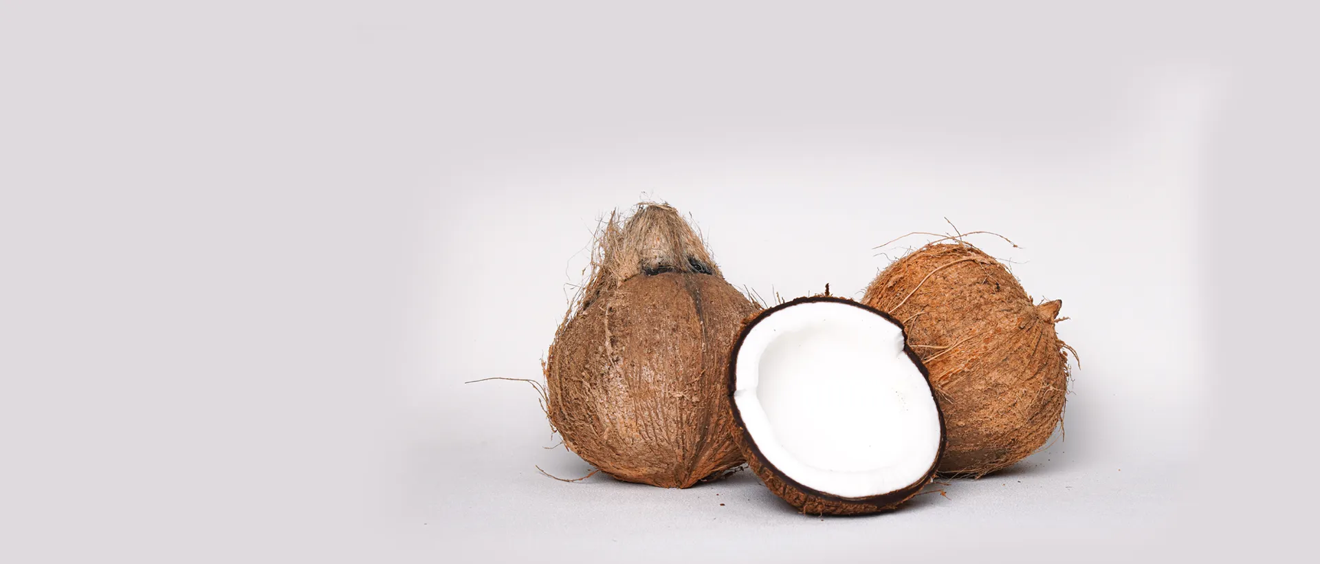 Whole and halved fresh coconuts